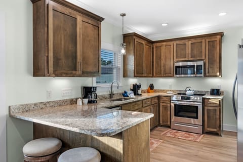 Kitchen - The copious kitchen features stainless appliances, granite counter tops, and a small eat-in style bar that offers additional seating.