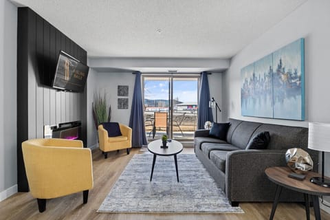 Living room with a Smart TV, electric fireplace, cozy seating options and walkout access to the ground-floor patio.
