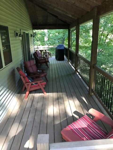 Main level covered deck with outdoor patio furniture and a Weber gas grill