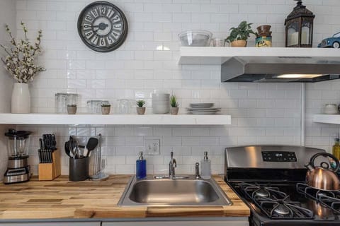 The kitchen has a small sink and plenty of dishes.