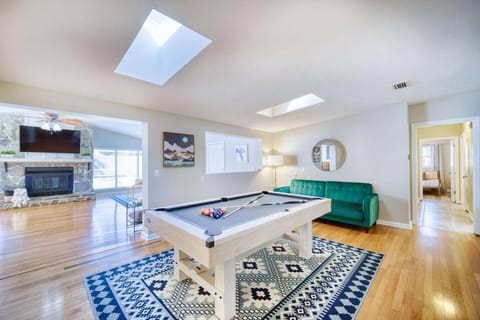 Bright and stylish home with a pool table, skylights, cozy fireplace, and vibrant décor for ultimate relaxation.