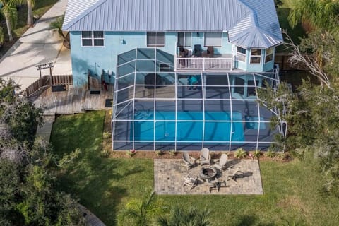 A bird’s-eye view of your private retreat—huge fenced yard, screened pool & hot tub, firepit, and plenty of space for furry friends and family fun.