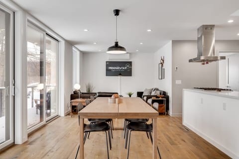 Gather around your spacious dining table while meals simmer on the sleek stovetop, sunlight streaming through floor-to-ceiling windows into this modern retreat.