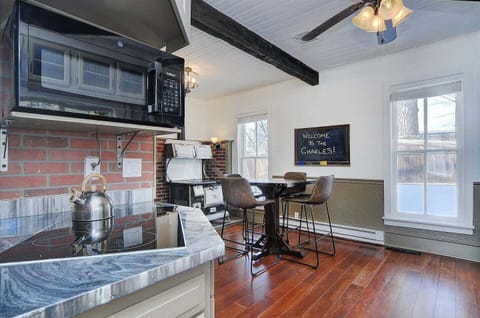 - Sunny breakfast nook with tall windows, rustic leather bar chairs, and cozy vibes
- Classic charm with exposed brick, antique stove, and chalkboard greeting sign
- Great for casual meals, board games, or morning coffee catch ups