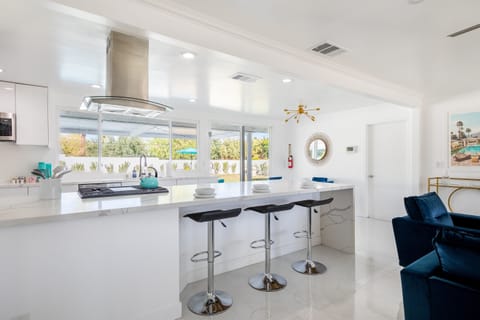 Enjoy breakfast at the sleek, modern breakfast bar, where the natural light streaming through the windows highlights the beauty of the spacious kitchen.