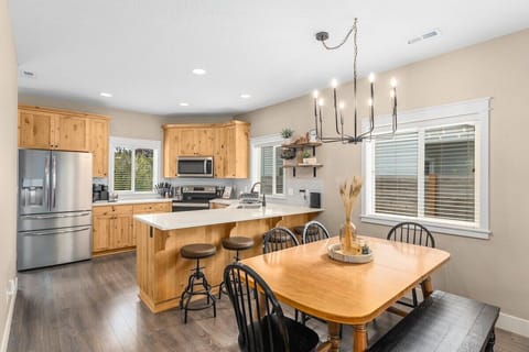 Seating for 10 and a fully stocked kitchen with appliances such as a refrigerator, oven, microwave, stove top, dishwasher, and Kuerig coffee maker.