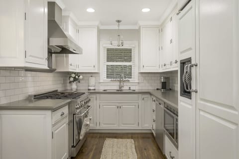 Chef's kitchen with 36in commercial range and modern finishes.