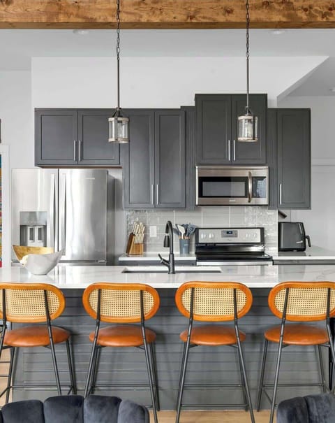 Modern island kitchen counter paired with stylish brown chairs.