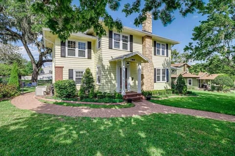 The exterior of this charming old wood home is cheerful and inviting, with lovely landscaping and shaded trees. Located just two houses up from Lake Hollingsworth, this historic home offers a picturesque and welcoming atmosphere.