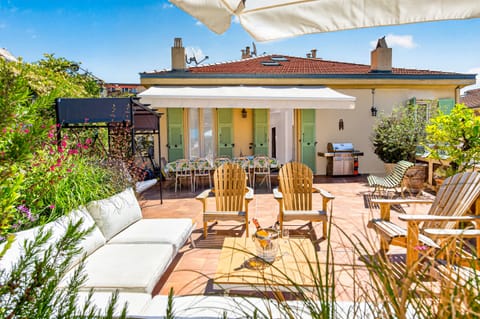 Terrace set up for guests' comfort with barbecue, dining table and benches.