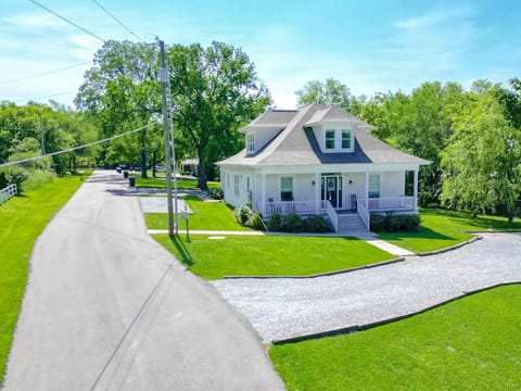 A classic white farmhouse exterior with a manicured lawn welcomes you to this Historic Franklin retreat.