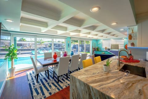 The updated kitchen is equipped with stainless steel appliances and granite waterfall countertops. The open concept allows you to overlook the pool deck and canal. Exposed wooden beams in the sunroom add to the modern but warm feel. 