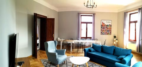 Living room with a huge table for 12 guests. There is TV