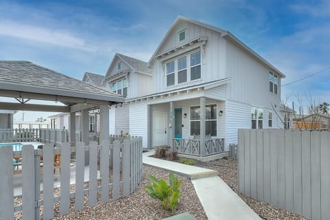 Charming coastal cottage with modern farmhouse charm and welcoming front porch in a peaceful neighborhood setting.
