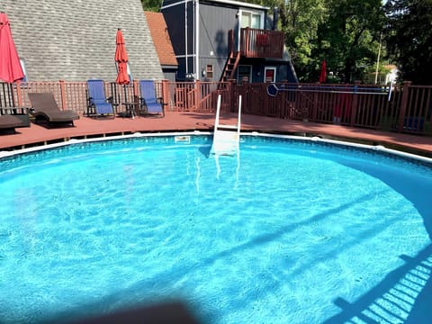 24' diameter outdoor above-ground summer pool with deck and chaise lounge chairs