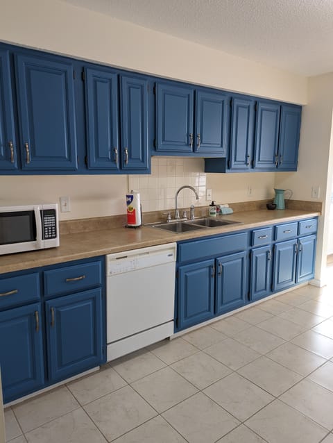 Large kitchen, fully stocked with dishes, pans, basic appliances, and silverware