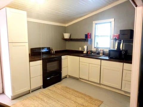 Kitchen including pantry, butcher board counter tops, electric range, microwave