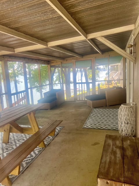 Screened porch with picnic table and lounge chairs