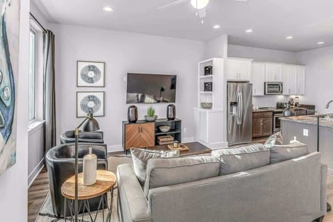 Modern living room with sunlight, plush seating, and Smart TV.