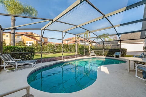 Screened-in pool area w/ sparkling water and lounge seating for easy indoor-outdoor relaxation.