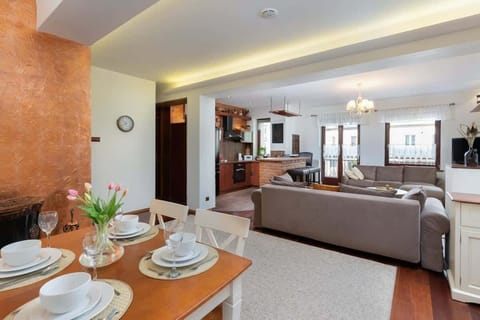 Stylish living room with a comfortable seating area, dining table, and warm lighting.