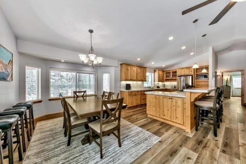 There are 4 tall chairs at the kitchen counter, plus 4 extra stools along the wall for additional seating.