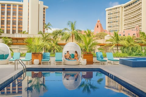 Sip and chat in a shaded cabana beside tranquil water.