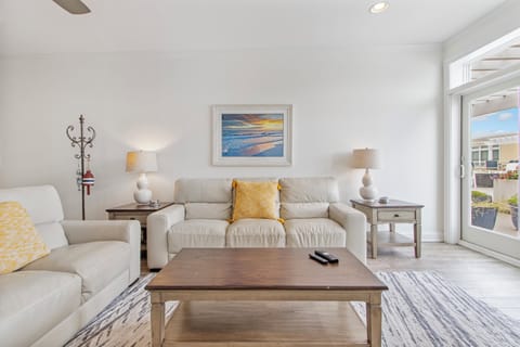 Living room with comfortable seating and access to 4th floor patio areas.