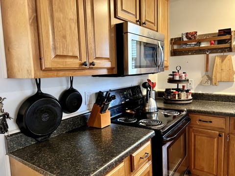 kettle, multiple coffee makers, spices, and other pantry items.