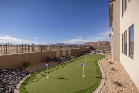 Putting green - This back view highlights the spacious back yard and private putting green.