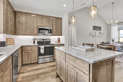 Kitchen with stove, oven, refrigerator, microwave, and coffee maker