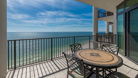Enjoy stunning beachfront views from the balcony's round table set, perfect for morning coffee or evening relaxation