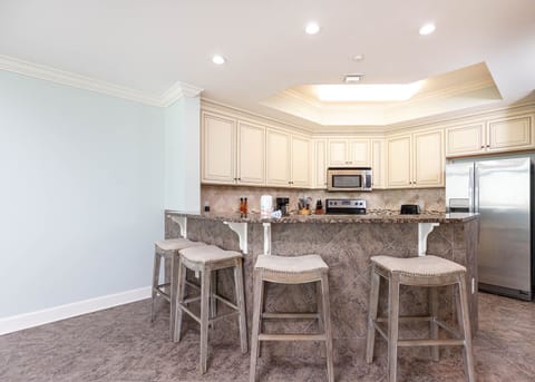 The kitchen features light cabinets, granite countertops, stainless appliances, and a coffee maker for a delightful stay
