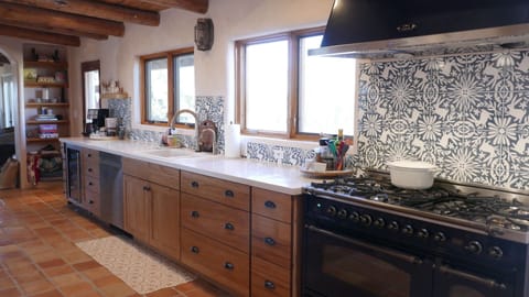 6-burner Italian gas range/griddle and rotisserie. Custom Conejo backsplash.