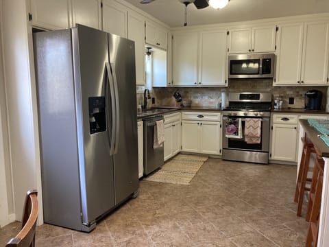 The full service kitchen is equipped with a dining area and a bar.