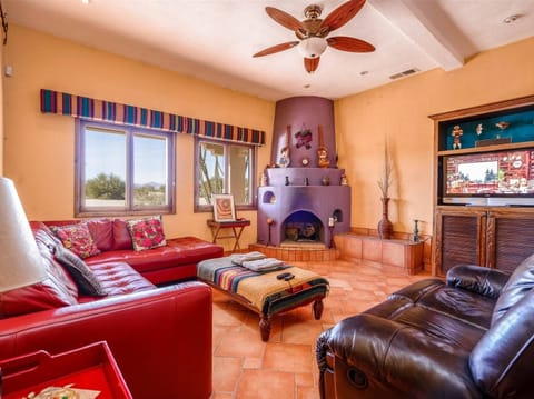 The living room at Casa Roja features comfortable seating, a flat-screen TV, and free Wi-Fi. Located inside the gated community of El Dorado Ranch.