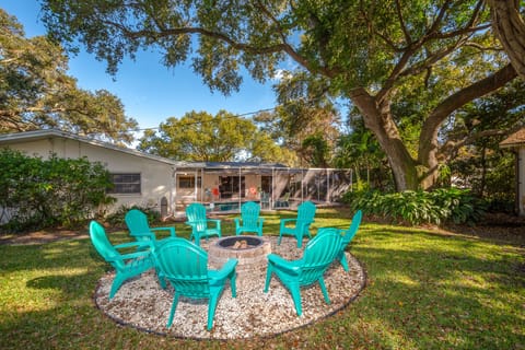 Large private backyard with custom fire pit surrounded by white sea shells.