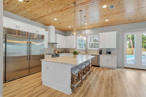 The kitchen flows seamlessly into the backyard pool/spa area.