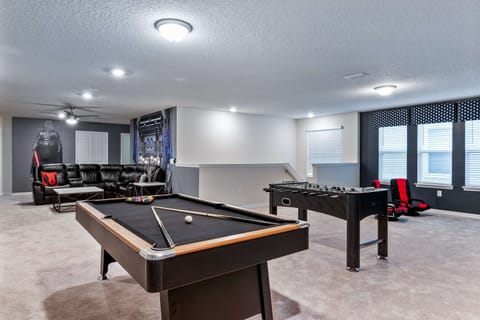 Expansive game room with pool table, foosball, theater seating, and sci-fi theme.