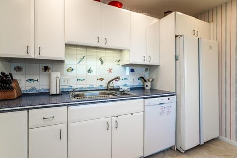 Updated kitchen with white cabinets with corain counter tops.
