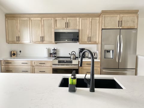 kitchen with induction stove, icemaker, coffee and espresso makers
