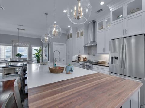 A spacious, airy kitchen with natural light features a central island for easy family interaction, a comfortable breakfast nook, and all the essential appliances, making it a practical and welcoming space for everyday cooking and connection.