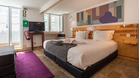 Nicely decorated bedroom area with a comfortable king size mattress and a TV.