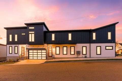 The striking black modern townhouse exterior glows at sunset, making a bold first impression on Argyle Ave.