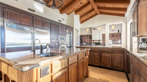 Oversized fridge & built in oven w/ views to indoor lounge & backyard.
