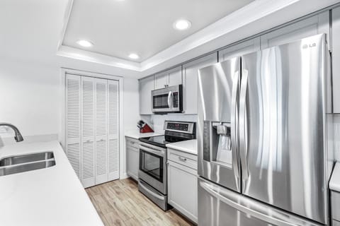 The updated kitchen features sleek stainless steel appliances and modern finishes