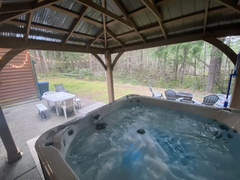 Large covered hot tub overlooking the private back yard and patio