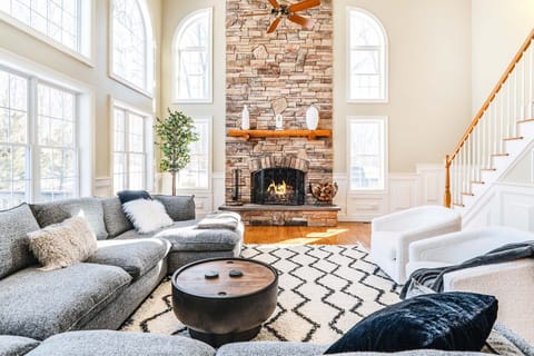 Great room with wood burning fireplace and 75 inch 4K smart TV