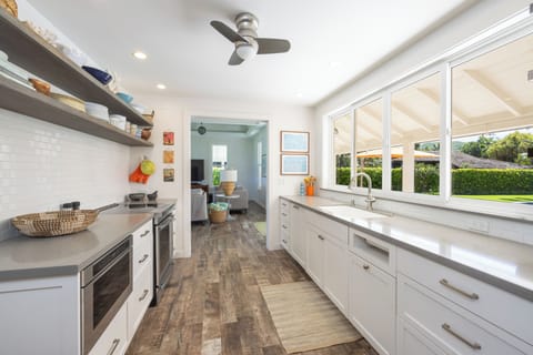 Galley kitchen looks out to the pool and into the living room.  