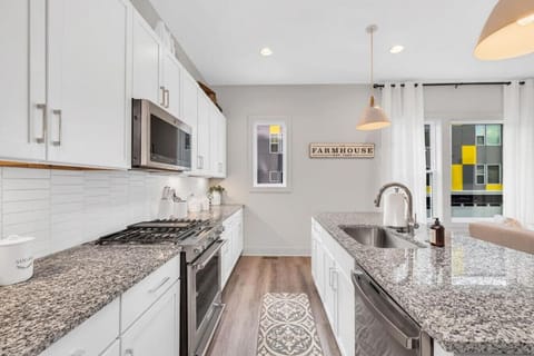 Kitchen with island stocked with pots, pans, and utensils
